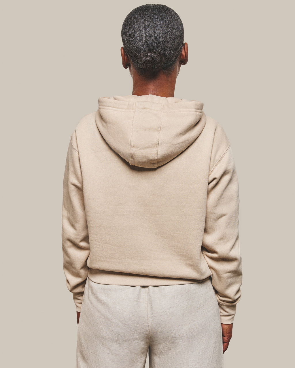 The back of the Hope Hoodie in Bone, hood down and plain with no print.