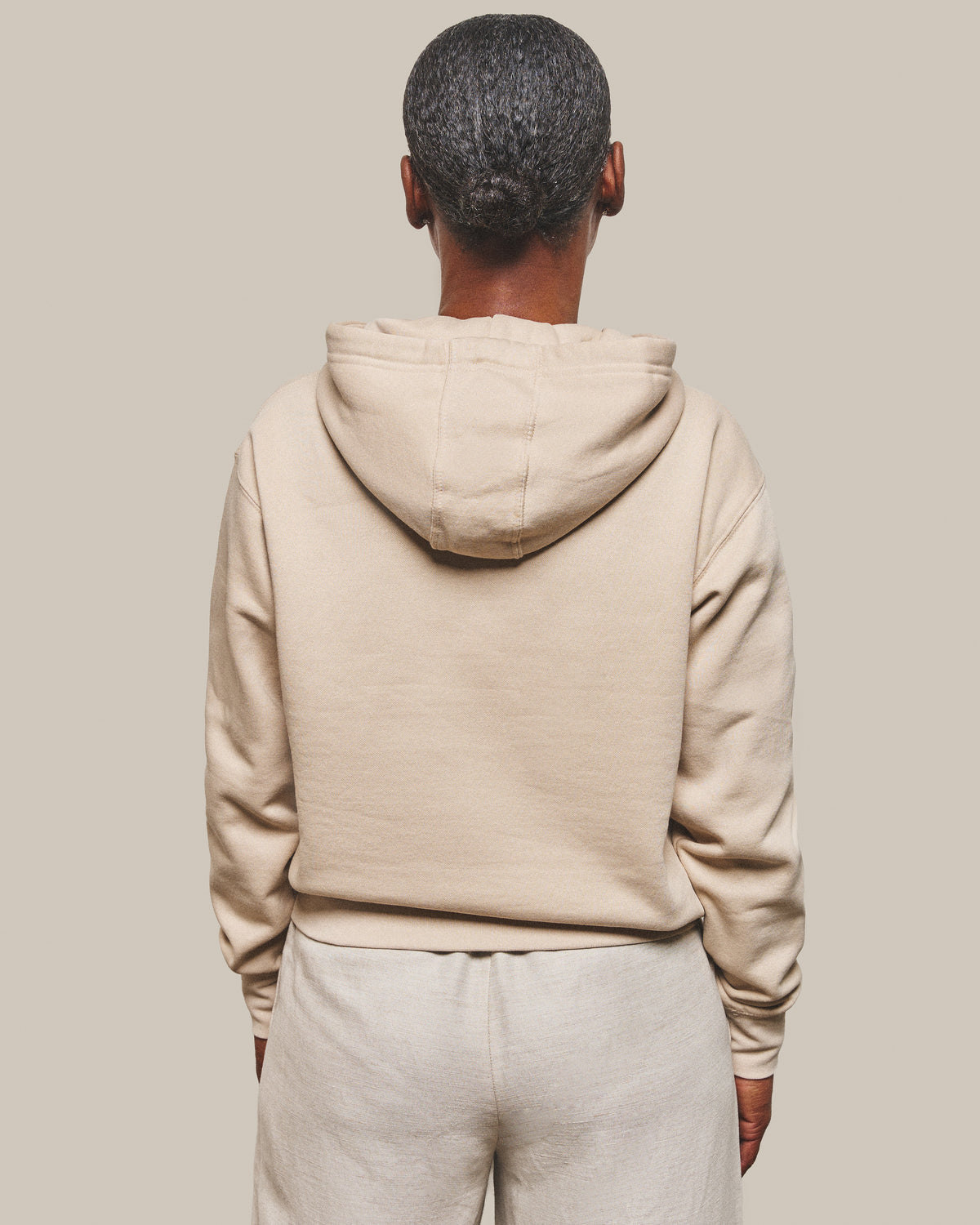 The back of the Hope Hoodie in Bone, hood down and plain with no print.