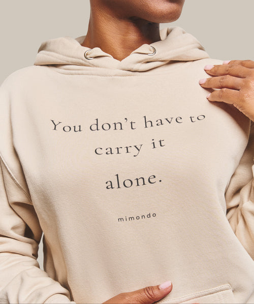 Close-up of the print on the Hope Hoodie: You don't have to carry it alone. With mimondo printed beneath.
